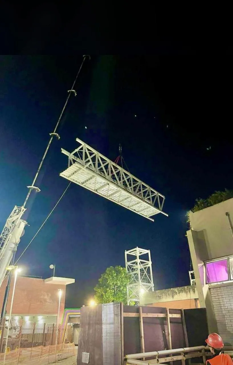 Passarela metálica suspensa pelo guindaste durante operação noturna na Estação Lapa