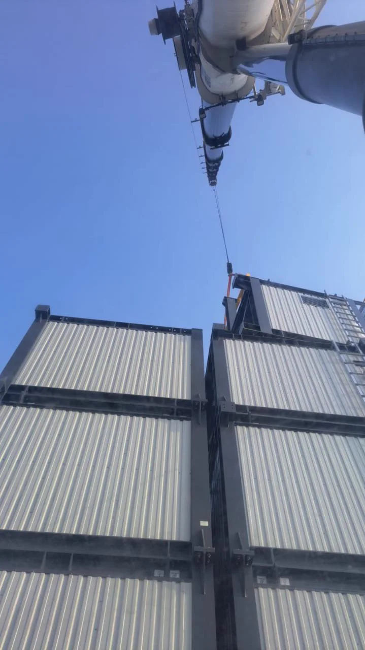 Vista inferior da lança do guindaste e dos módulos da usina de concreto durante a montagem