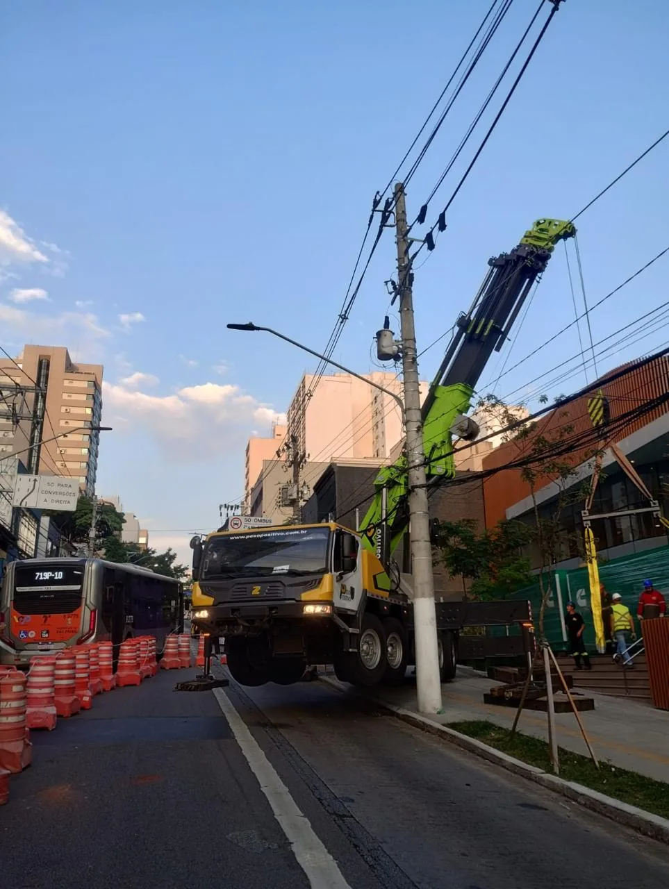 Vista ampla do guindaste Zoomlion Peso Positivo operando sobre rede elétrica com via interditada
