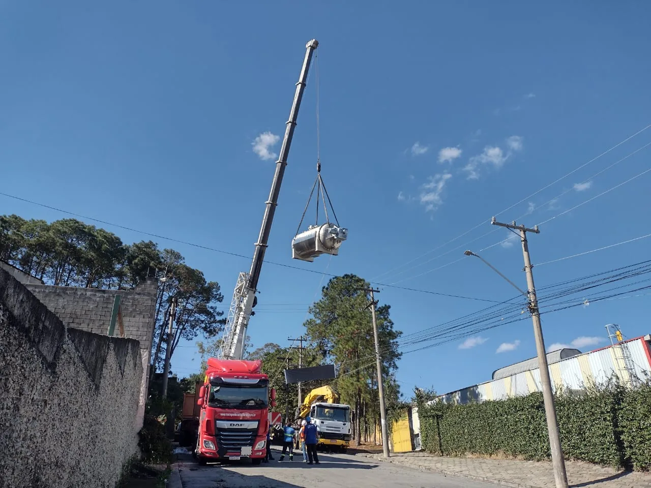 Vista da autoclave centralizada sobre a via, guindaste com lança estendida transpor fiação e árvores