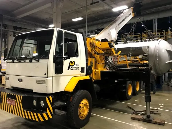 Caminhão munck da Peso Positivo realizando içamento de tanque industrial
